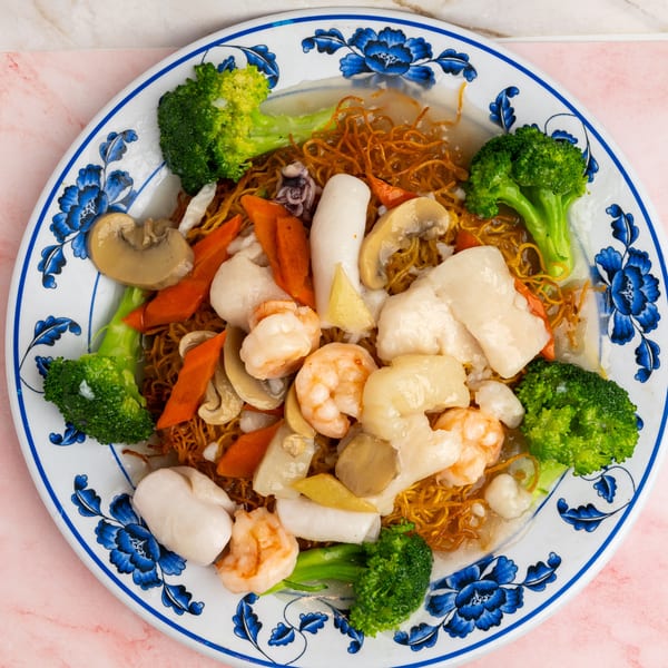 Crispy noodles topped with shrimp, scallops, squid, broccoli, carrots, and mushrooms in sauce.