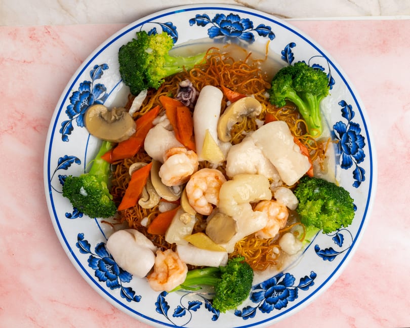 Crispy noodles topped with shrimp, scallops, squid, broccoli, carrots, and mushrooms in sauce.